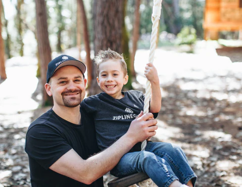 Parent and Child smiling while on a zipline