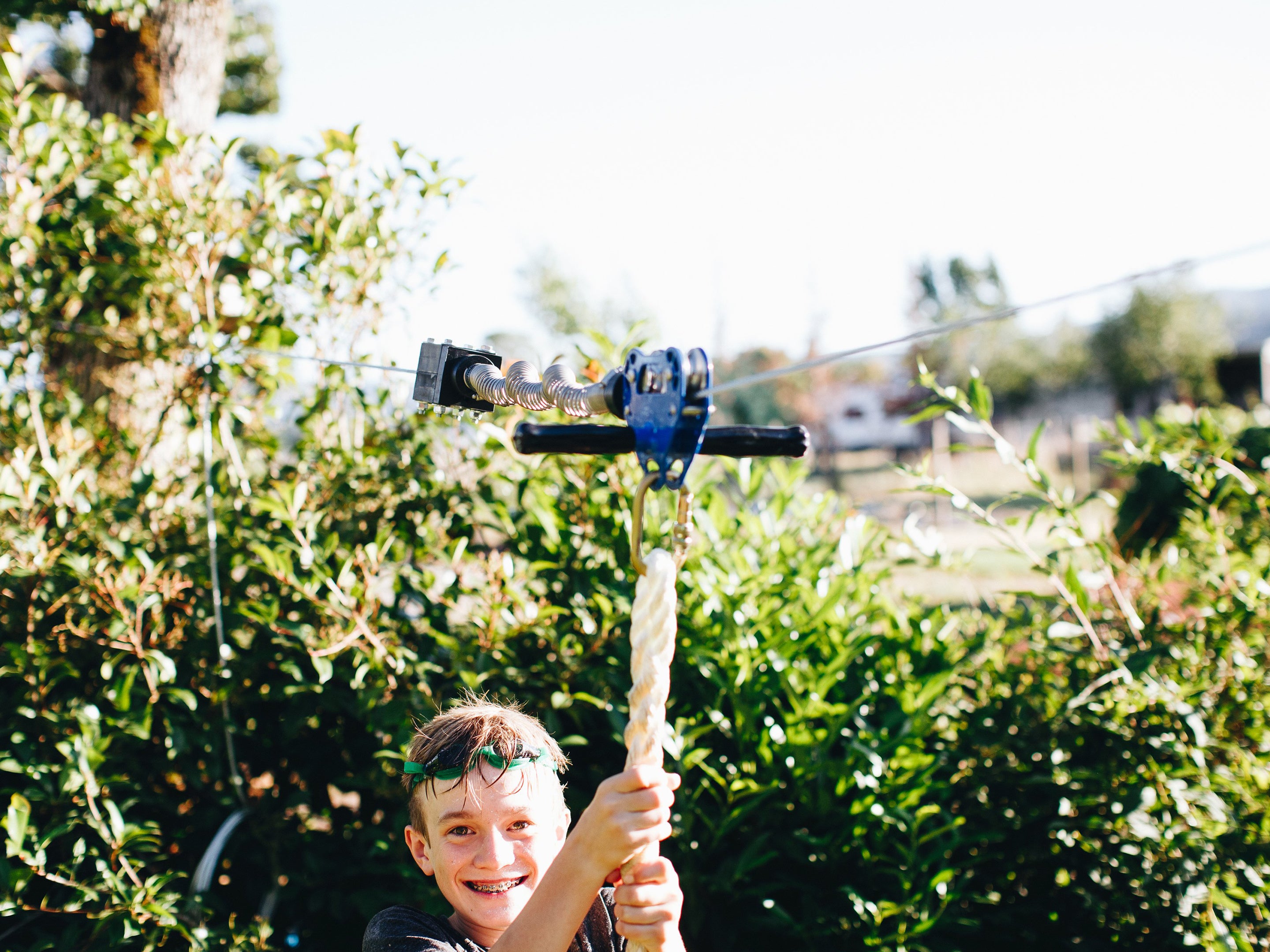 Boy riding a zip line using the spring stop